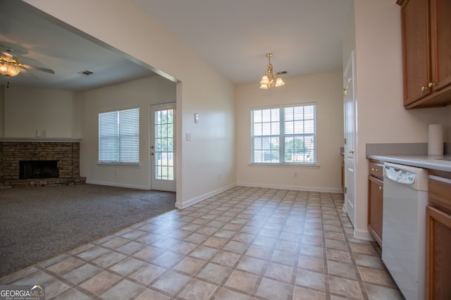 kitchen featuring light tile patterned floors, a fireplace, ceiling fan with notable chandelier, and dishwasher