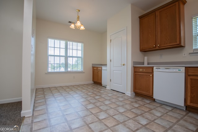 kitchen with light tile patterned floors, white dishwasher, and an inviting chandelier