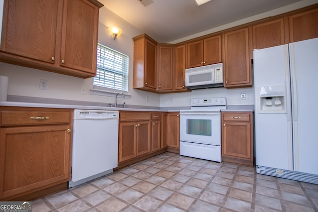 kitchen featuring light tile patterned flooring, sink, and white appliances