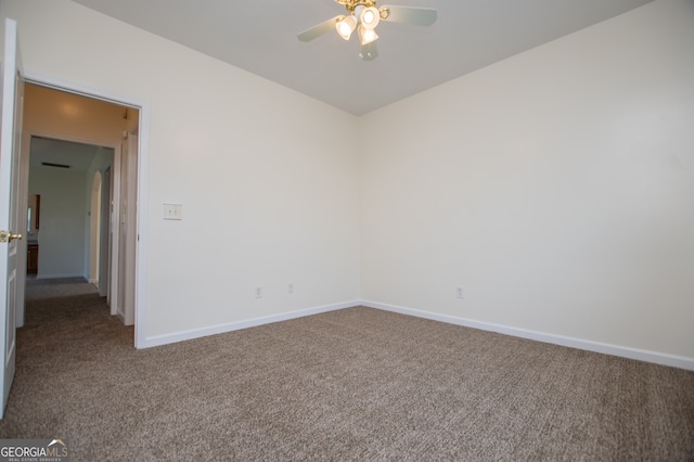 carpeted spare room featuring ceiling fan