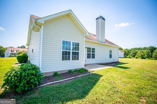 rear view of property featuring a patio and a yard