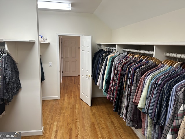 spacious closet featuring vaulted ceiling and light wood-type flooring