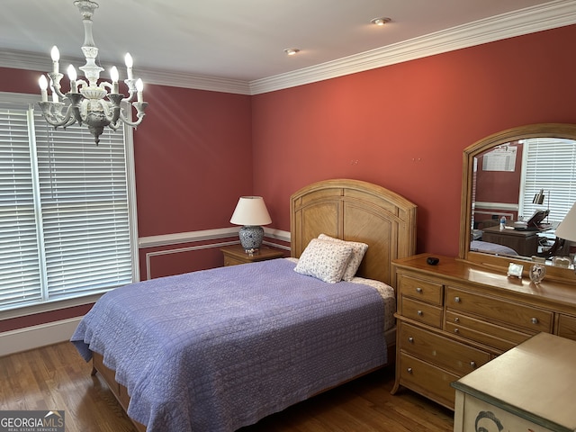 bedroom with dark hardwood / wood-style floors, crown molding, and an inviting chandelier