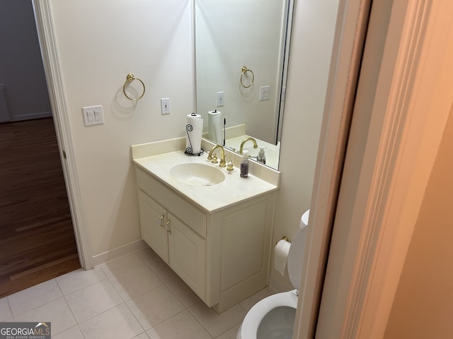 bathroom with toilet, hardwood / wood-style floors, and vanity