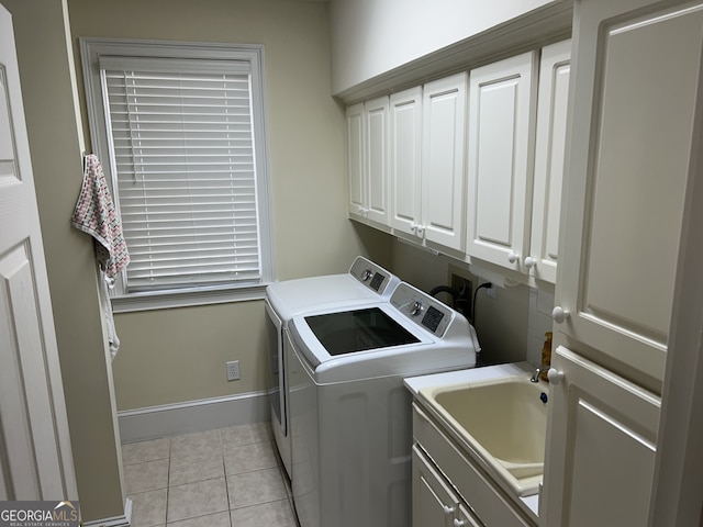 laundry room featuring washer and clothes dryer, sink, cabinets, and light tile patterned floors