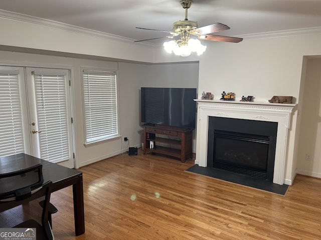 living room featuring ornamental molding, light hardwood / wood-style flooring, ceiling fan, and french doors