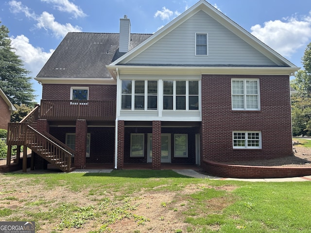 rear view of house with a yard and a wooden deck