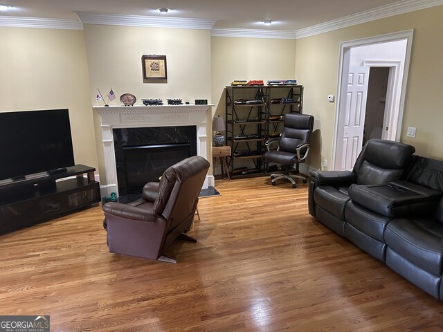 living room featuring hardwood / wood-style flooring, crown molding, and a high end fireplace