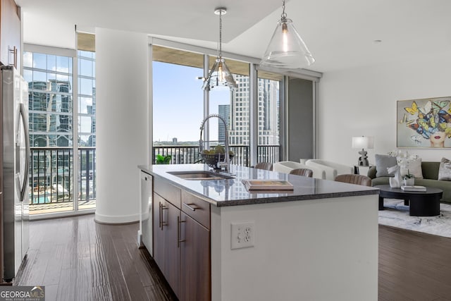 kitchen featuring sink, stainless steel appliances, dark hardwood / wood-style flooring, expansive windows, and pendant lighting