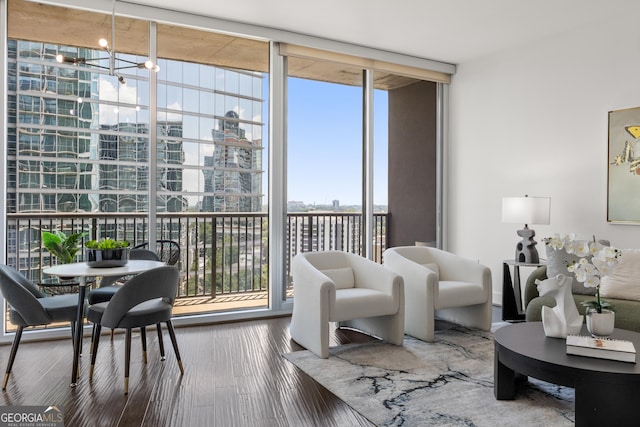 living room featuring a chandelier, hardwood / wood-style floors, and expansive windows