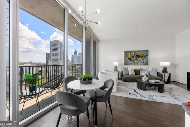 dining space with a notable chandelier, floor to ceiling windows, wood-type flooring, and a wealth of natural light