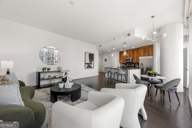 living room featuring dark hardwood / wood-style flooring and an inviting chandelier