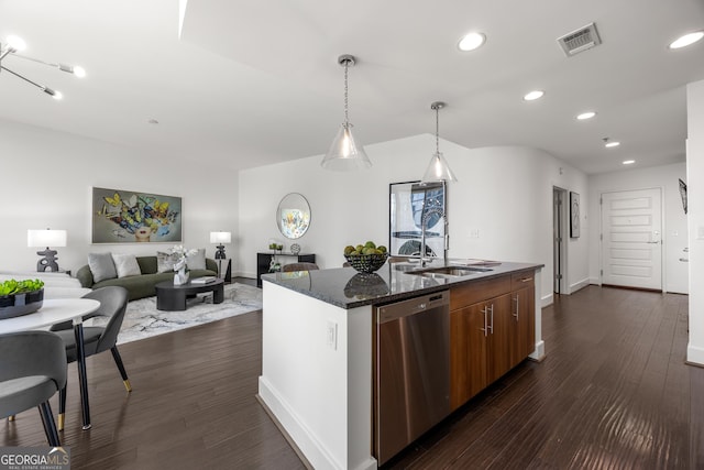 kitchen featuring dishwasher, dark hardwood / wood-style floors, dark stone counters, pendant lighting, and a kitchen island with sink