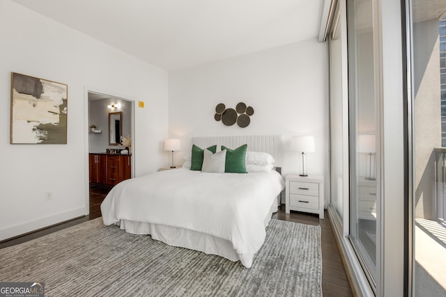 bedroom with dark hardwood / wood-style flooring and ensuite bath