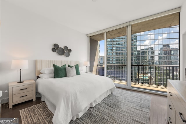 bedroom featuring dark hardwood / wood-style floors, floor to ceiling windows, and access to outside