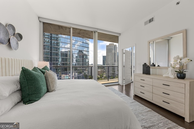 bedroom featuring access to outside, floor to ceiling windows, and dark hardwood / wood-style flooring