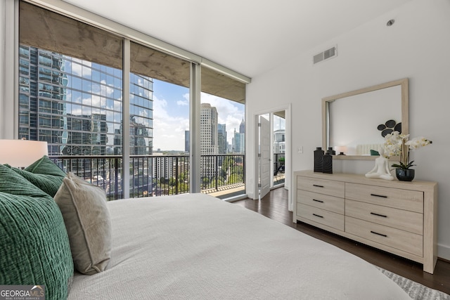 bedroom featuring dark hardwood / wood-style flooring, access to outside, and floor to ceiling windows