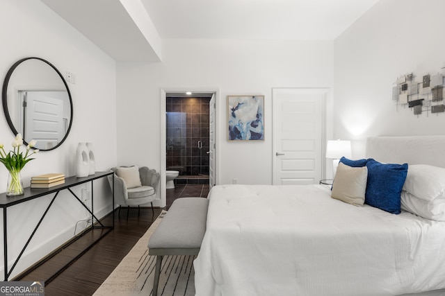 bedroom with ensuite bathroom and dark wood-type flooring