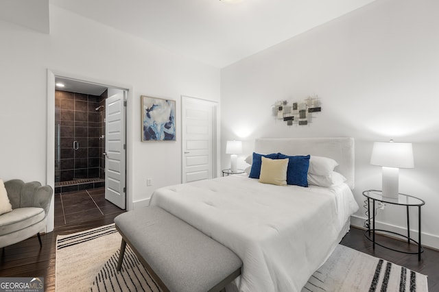 bedroom featuring ensuite bathroom and dark wood-type flooring