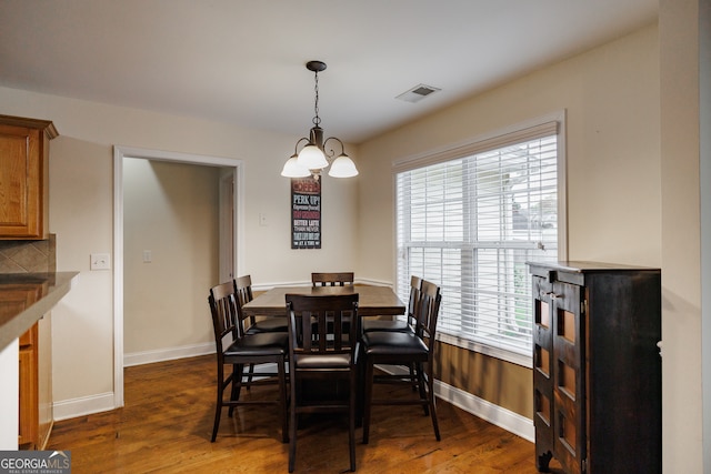 dining space featuring a notable chandelier and dark hardwood / wood-style floors