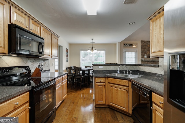 kitchen with sink, black appliances, tasteful backsplash, a chandelier, and dark wood-type flooring