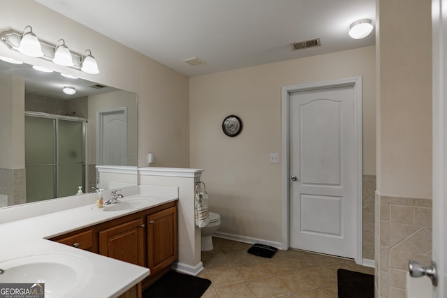 bathroom with vanity, a shower with shower door, tile patterned flooring, and toilet