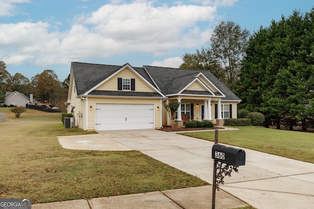 craftsman-style home featuring a garage, cooling unit, and a front lawn