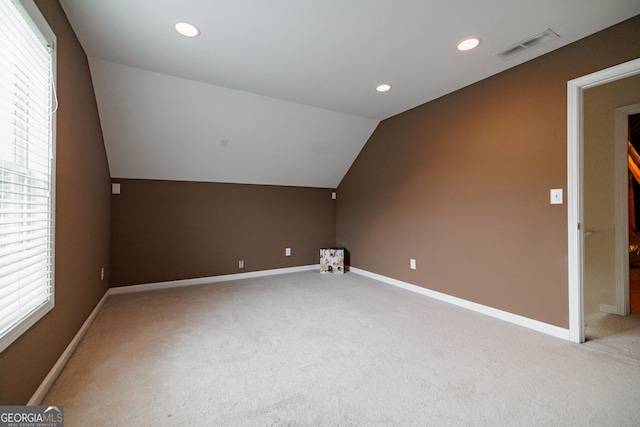 bonus room with a healthy amount of sunlight, vaulted ceiling, and carpet floors