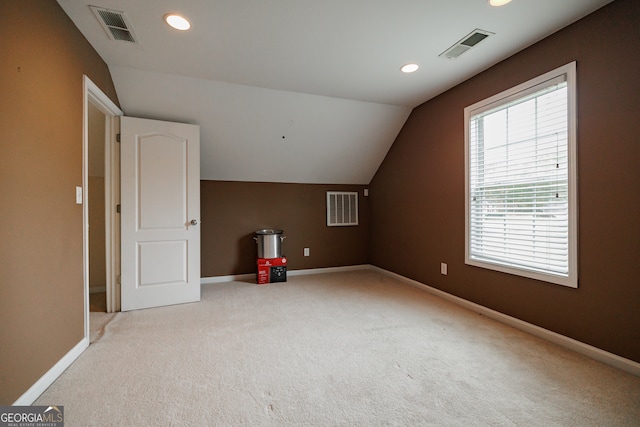 bonus room featuring lofted ceiling and light carpet