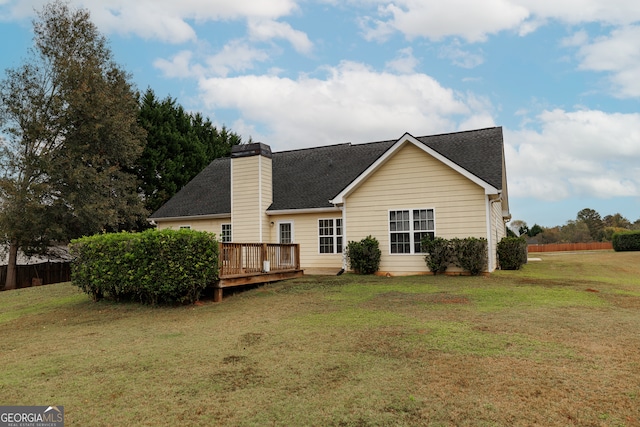 rear view of house with a deck and a lawn