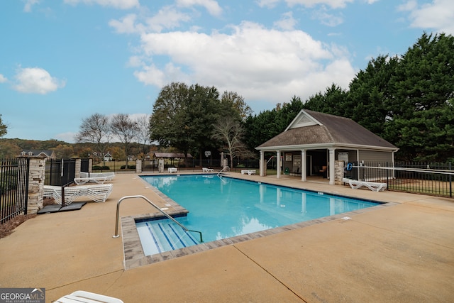 view of swimming pool with an outdoor structure and a patio area