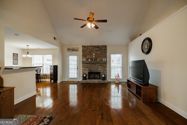 unfurnished living room with high vaulted ceiling, ceiling fan with notable chandelier, dark hardwood / wood-style floors, and a fireplace