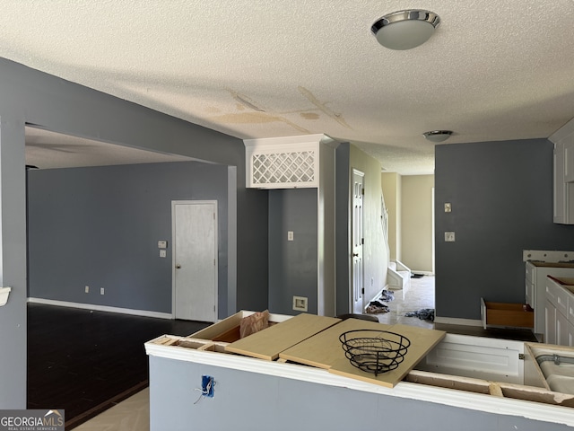 kitchen with a textured ceiling and white cabinets