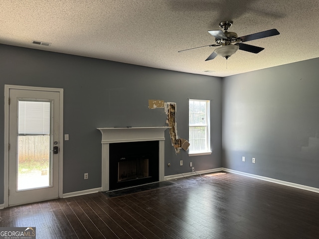 unfurnished living room with ceiling fan, dark wood-type flooring, and a textured ceiling