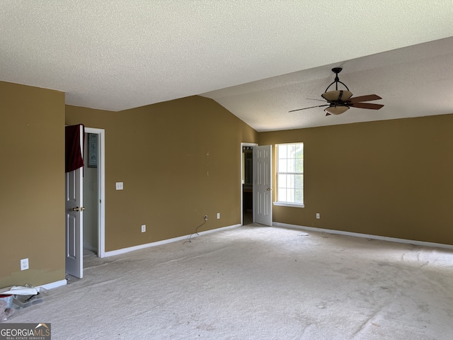 carpeted empty room featuring vaulted ceiling, a textured ceiling, and ceiling fan