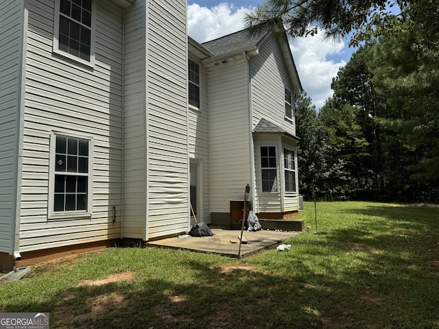 back of house featuring a patio area and a lawn