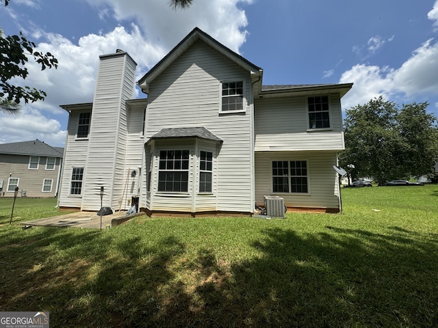 rear view of house featuring central AC, a patio area, and a lawn