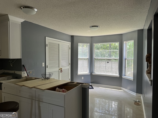 kitchen featuring white cabinetry and a textured ceiling