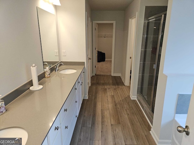 bathroom with a shower with door, vanity, and hardwood / wood-style flooring