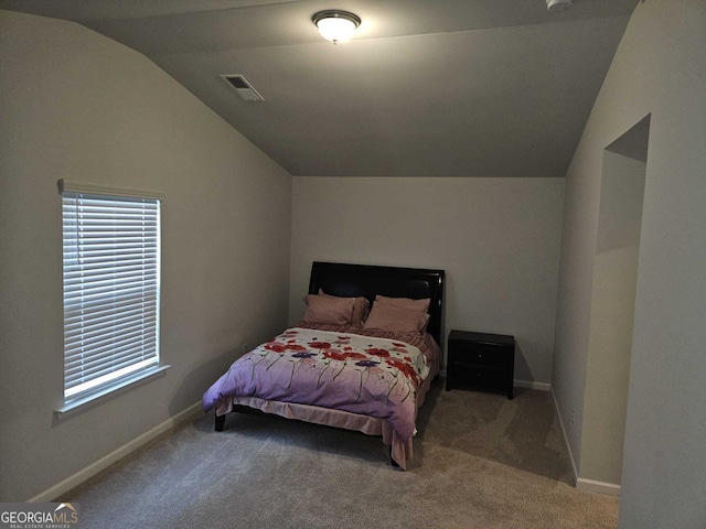 bedroom featuring lofted ceiling and carpet