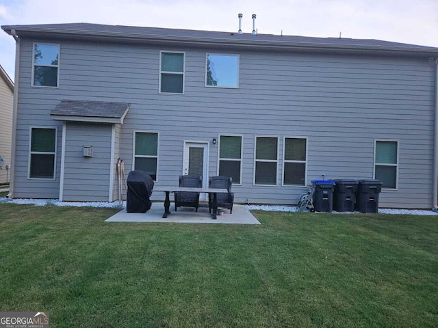 back of property with a lawn and a patio area