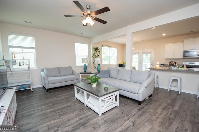 living room featuring ceiling fan and dark hardwood / wood-style flooring