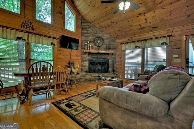 living room with a healthy amount of sunlight, hardwood / wood-style floors, and high vaulted ceiling