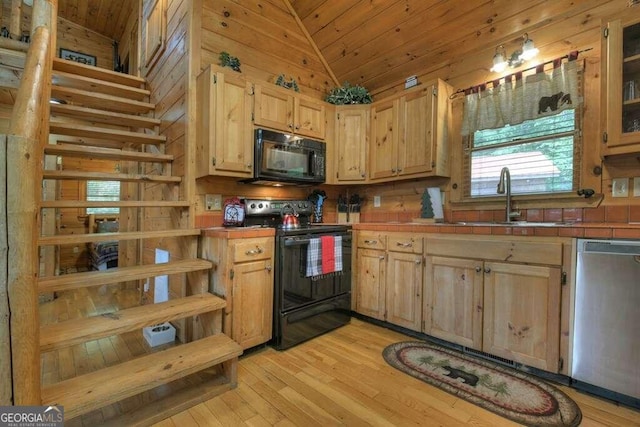 kitchen featuring lofted ceiling, black appliances, tile countertops, and light wood-type flooring