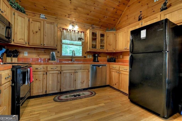 kitchen with light hardwood / wood-style floors, sink, black appliances, and lofted ceiling