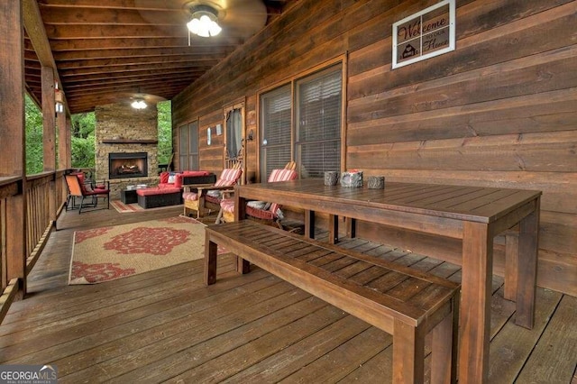 deck with an outdoor stone fireplace