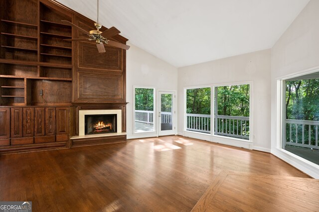 unfurnished living room with high vaulted ceiling, light wood-type flooring, and ceiling fan