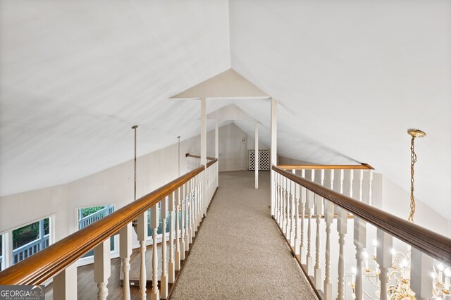 hallway featuring vaulted ceiling and carpet