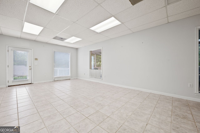 tiled spare room with a drop ceiling and plenty of natural light