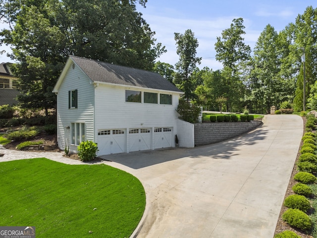 view of side of property featuring a garage and a yard